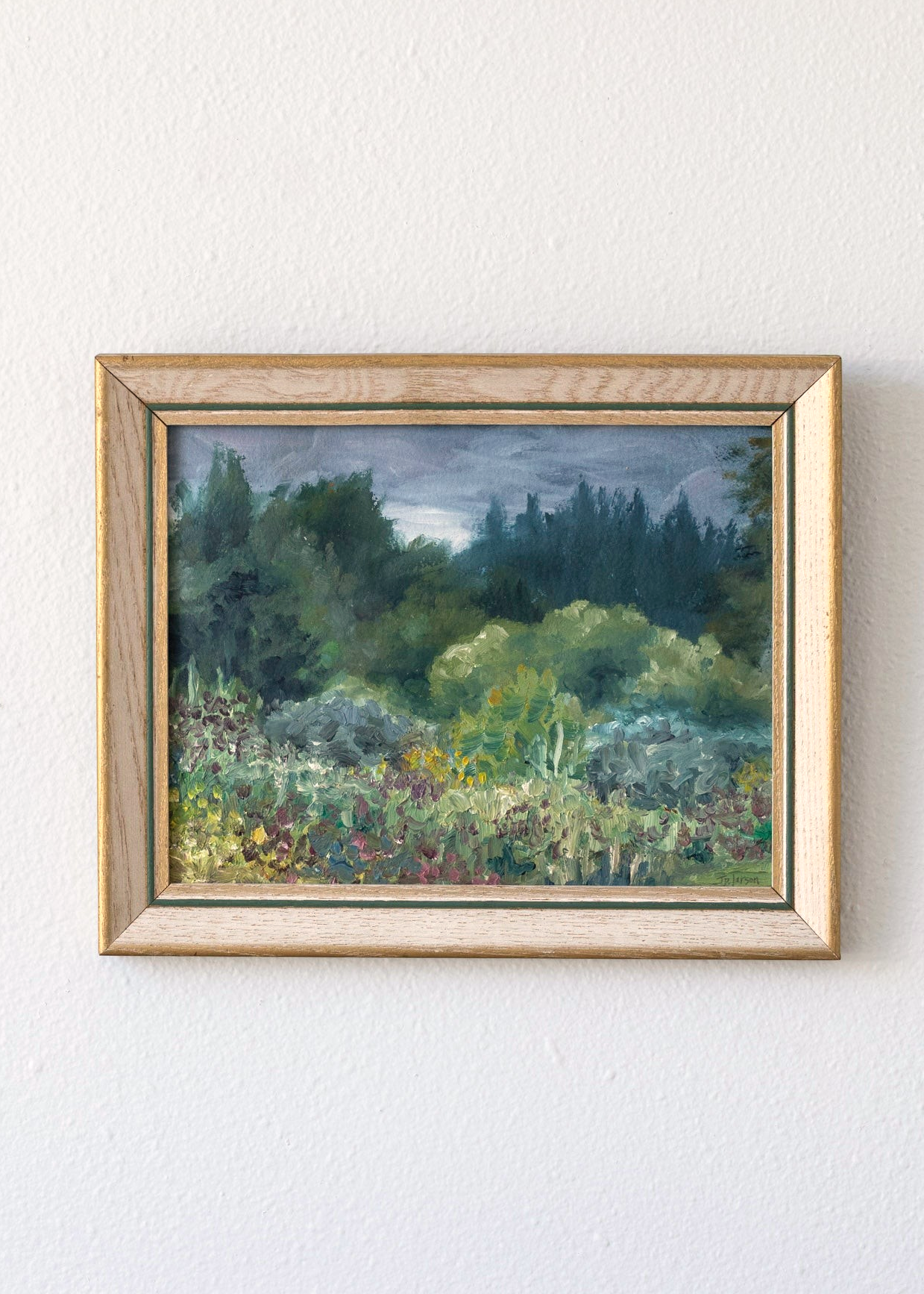 Hoppe Shoppe vintage landscape painting by JP Larson featuring a moody garden scene in a wood frame on a white wall.