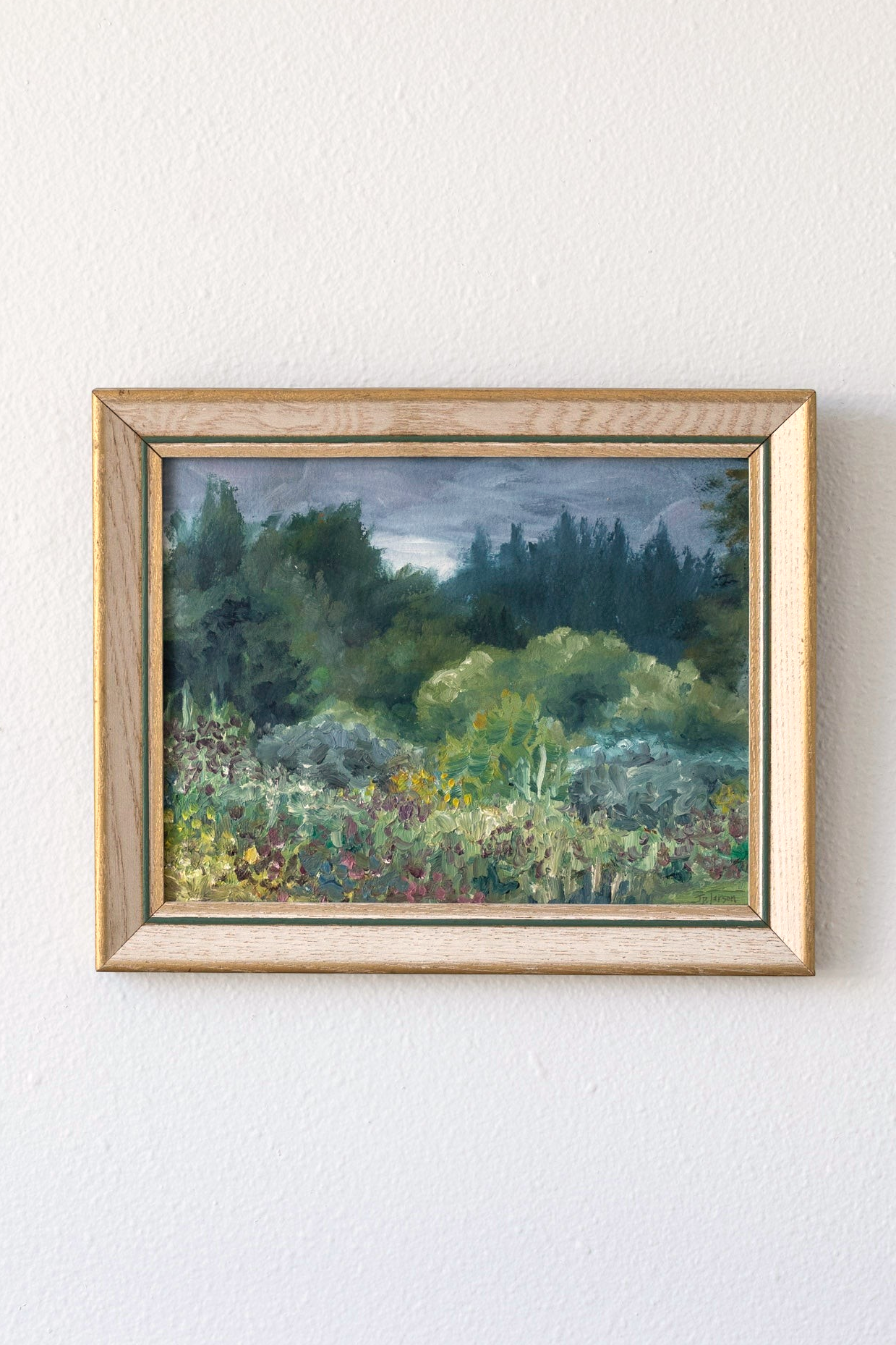 Hoppe Shoppe vintage landscape painting by JP Larson featuring a moody garden scene in a wood frame on a white wall.